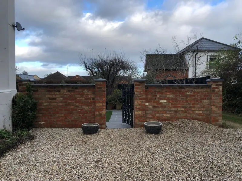 Before: a bare gravel front garden behind a brick wall